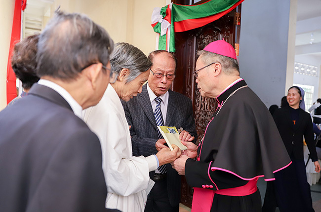 Chủ tịch Hội đồng Giám mục Việt Nam Nguyễn Chí Linh đón tiếp và nhận món quà từ một nhân sĩ. Ảnh: Nguyễn Đông.