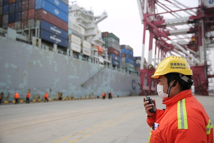 Một quản đốc đeo khẩu trang làm việc trước một tàu chở hàng cập cảng Thanh Đảo, tỉnh Sơn Đông, Trung Quốc hôm 4/2. Ảnh: Reuters
