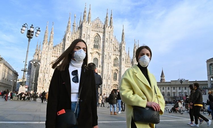 Người dân đeo khẩu trang khi đi qua quảng trường Piazza del Duomo ở thành phố Milan hôm 23/2. Ảnh: AFP.