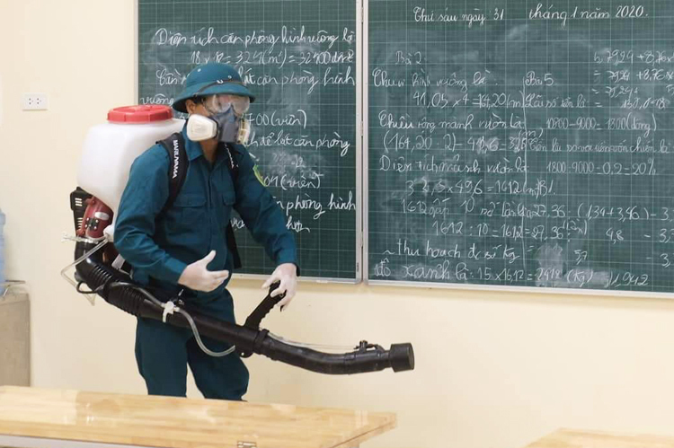 Nhân viên phòng dịch phun thuốc khử khuẩn tại trường tiểu học Hoàng Diệu, Hà Nội. Ảnh: Ngọc Thành.