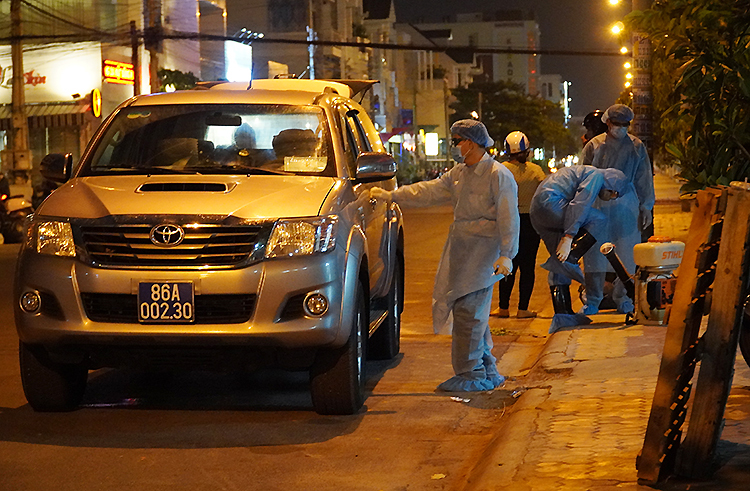 Nhân viên y tế chuẩn bị phun thuốc khử trùng khu vực nhà bệnh nhân 34 ở thành phố Phan Thiết, tối 10/3. Ảnh: Việt Quốc.